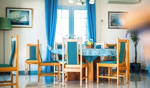 A dining area with wooden chairs and a table covered with a patterned tablecloth. - Plaça de sa Punta, 4, 07750 Cala Galdana, Balearic Islands, Spanyolország (Cala Galdana)