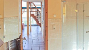 A hotel hallway with a tiled floor, a glass shower enclosure, and a wooden staircase leading to an outdoor area. - Cozy apartment in Börgerende-Rethwisch (Börgerende-Rethwisch)
