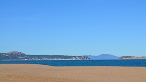 Una spiaggia con cielo sereno e montagne in lontananza.