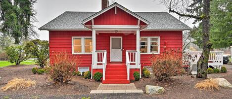 Ein rotes Haus mit einer weißen Veranda und Stufen zum Eingang.