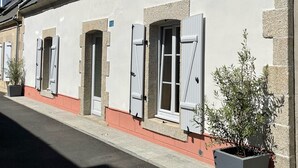 Une rangée de bâtiments traditionnels aux façades en pierre, aux murs peints en blanc et aux fenêtres à volets.