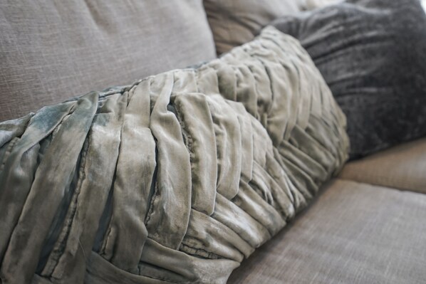 A close-up of a sofa with a textured, wrinkled fabric and a visible seam.