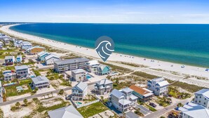 A coastal residential area with beachfront properties, including houses with balconies and a swimming pool. - Sunset Dreamer- Beachfront MB Home- Priv. Pool, Pet Friendly, Hot Tub, Sleeps 13 (Mexico Beach)