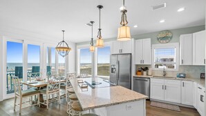 A modern kitchen with a central island, white cabinetry, stainless steel appliances, and pendant lighting. - Sunset Dreamer- Beachfront MB Home- Priv. Pool, Pet Friendly, Hot Tub, Sleeps 13 (Mexico Beach)