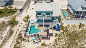 A two-story beachfront property with a swimming pool, outdoor seating, and a slide. - Sunset Dreamer- Beachfront MB Home- Priv. Pool, Pet Friendly, Hot Tub, Sleeps 13 (Mexico Beach)