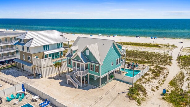 A beachfront property with multiple buildings, a swimming pool, and a beach view. - Sunset Dreamer- Beachfront MB Home- Priv. Pool, Pet Friendly, Hot Tub, Sleeps 13 (Mexico Beach)