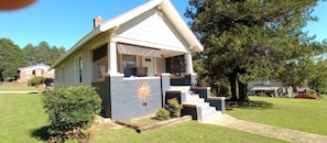 A single-story house with a gabled roof, a front porch, and a brick accent wall.