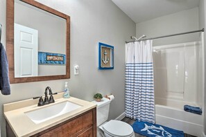 Un baño con lavamanos, inodoro y bañera.