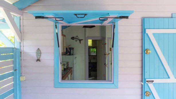 Une pièce avec une fenêtre, une porte et un motif décoratif représentant un poisson sur le mur.