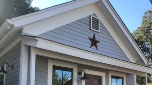 A small, single-story building with a brown door, white trim, and a star decoration above the door. - Downtown Cozy Cottage, two blocks from downtown and new! (Paso Robles)