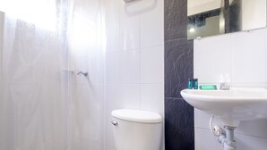 Un baño con inodoro, ducha y lavamanos.