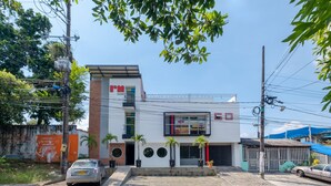 Un hotel moderno con techo plano, un balcón y un letrero que indica que es un hotel.