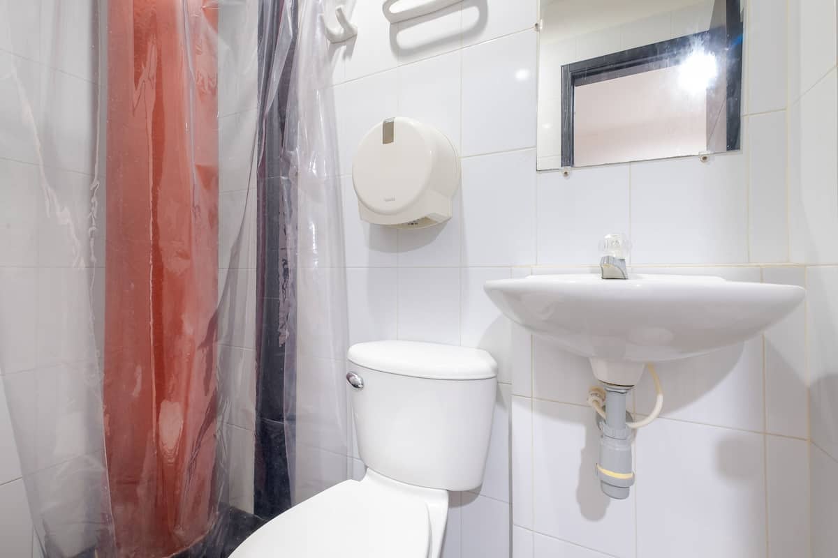 A bathroom with a toilet, sink, and a hand dryer.