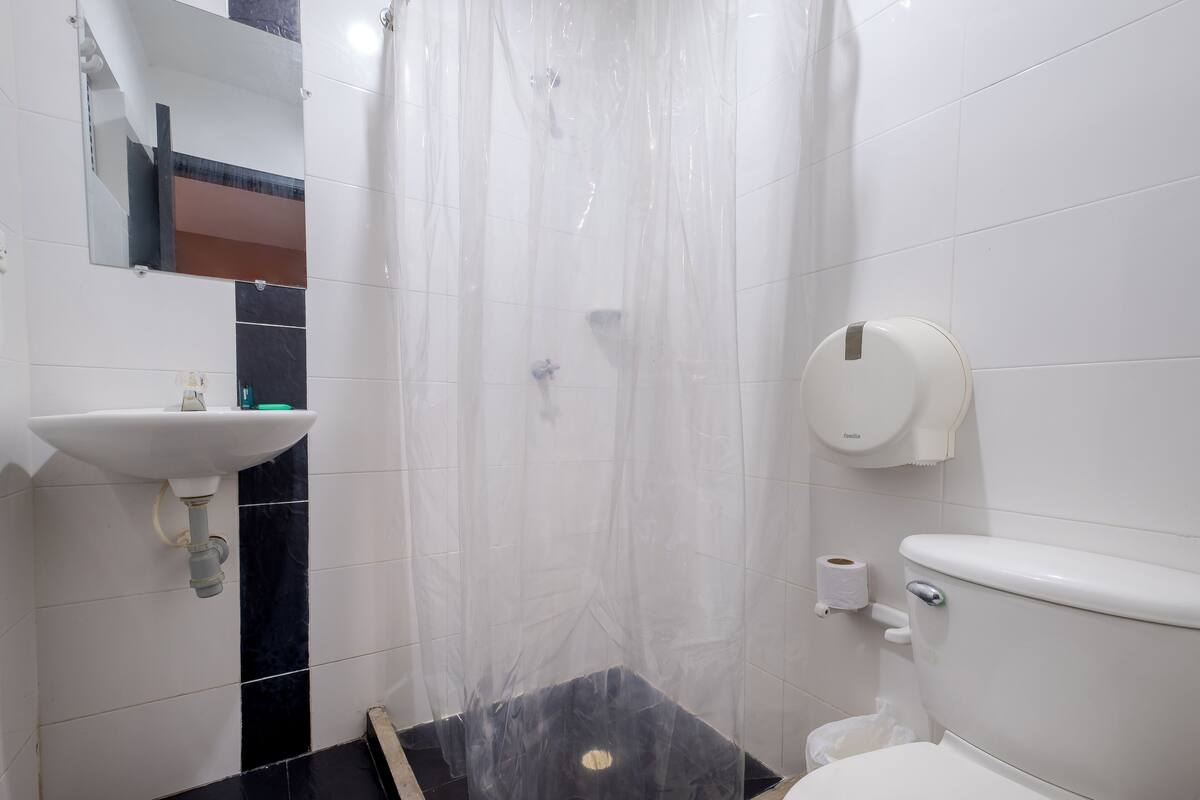 A bathroom with a white sink, a toilet, and a shower curtain.