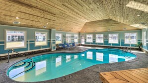 An indoor swimming pool with a wooden ceiling, clear windows, and a lounge area with chairs. - Emerald Isle Condo w/ Indoor Pool & Beach Access! (Emerald Isle)