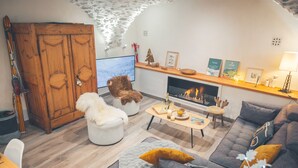 Un salon chaleureux avec une cheminée, des meubles en bois et un plafond en pierre.