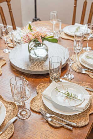 Formal dining experience awaits with a beautifully set table featuring fine china, glassware, and a floral centerpiece.