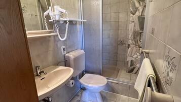 Un baño con inodoro, lavamanos y ducha.