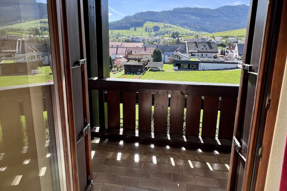 A balcony with a view of a town and mountains.