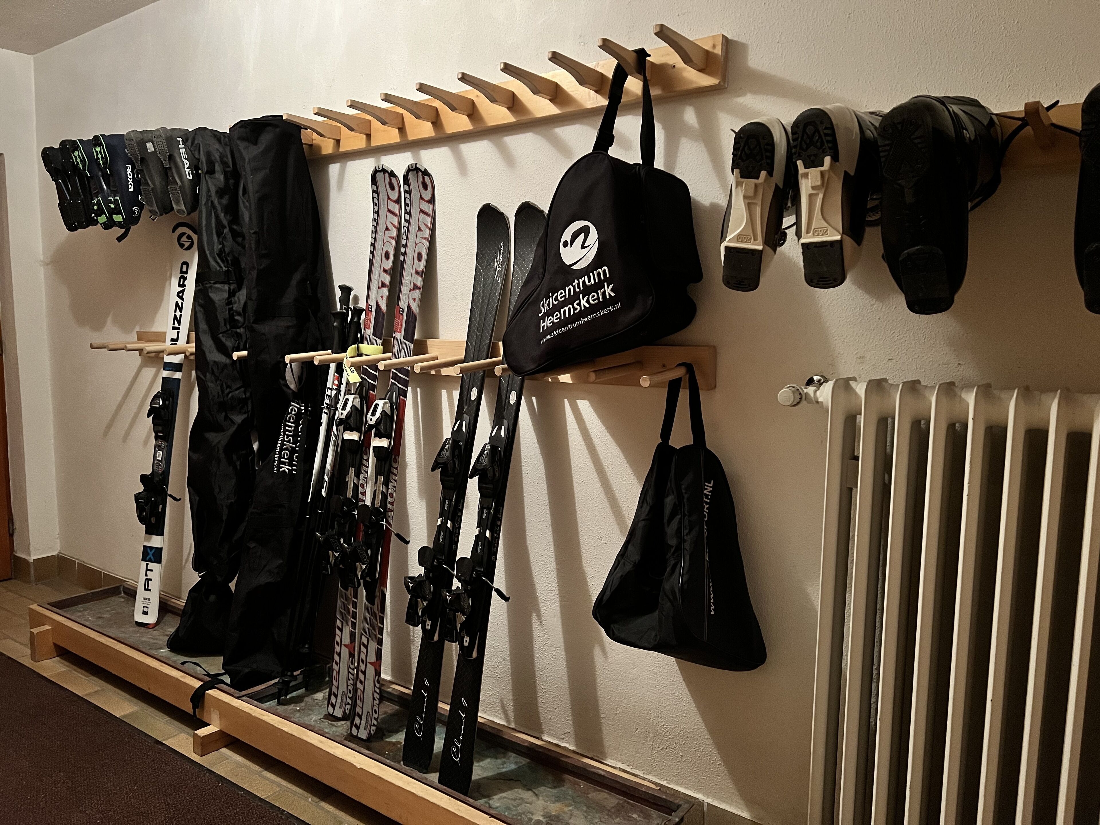 Ein Skiraum mit Skiern, Skischuhen und Taschen.