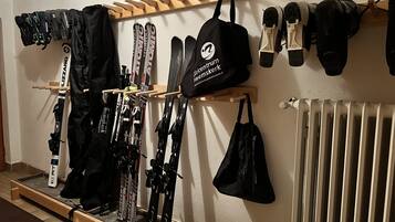 Ein Skiraum mit Skiern, Skischuhen und Taschen.