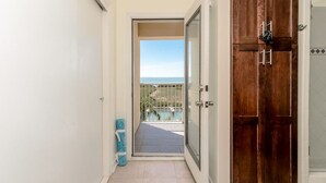 A hallway leading to a balcony with a view of the sea. - Modern Family SPI Retreat- Waterfront, Wildlife, Sunrise & Sunset Views (South Padre Island)