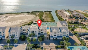A beachfront hotel with multiple-story buildings, a swimming pool, and a beach area. - Modern Family SPI Retreat- Waterfront, Wildlife, Sunrise & Sunset Views (South Padre Island)