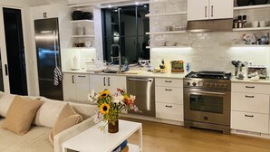 A modern kitchen with white cabinetry, stainless steel appliances, and a central island. - Up-island vibe, down-island conveniences. (Edgartown)