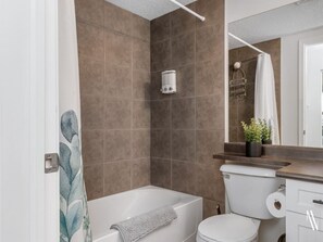 Un bagno con vasca, servizi igienici e zona doccia.
