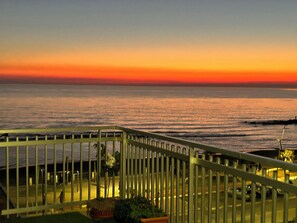 A balcony with a railing overlooking a sunset over the ocean. - LUXURY BY THE SEA (Lido di Ostia)