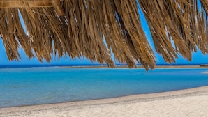 Una playa con aguas azul turquesa y una orilla arenosa.