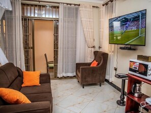 Una sala de estar con sofá, sillón, televisor y una mesa de centro.