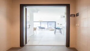 Un pasillo que conduce a una habitación con vista a un balcón y un comedor.