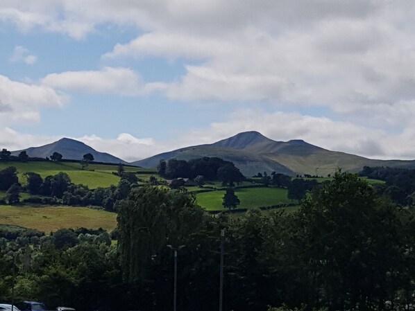 A landscape with rolling hills and a mountain in the background.