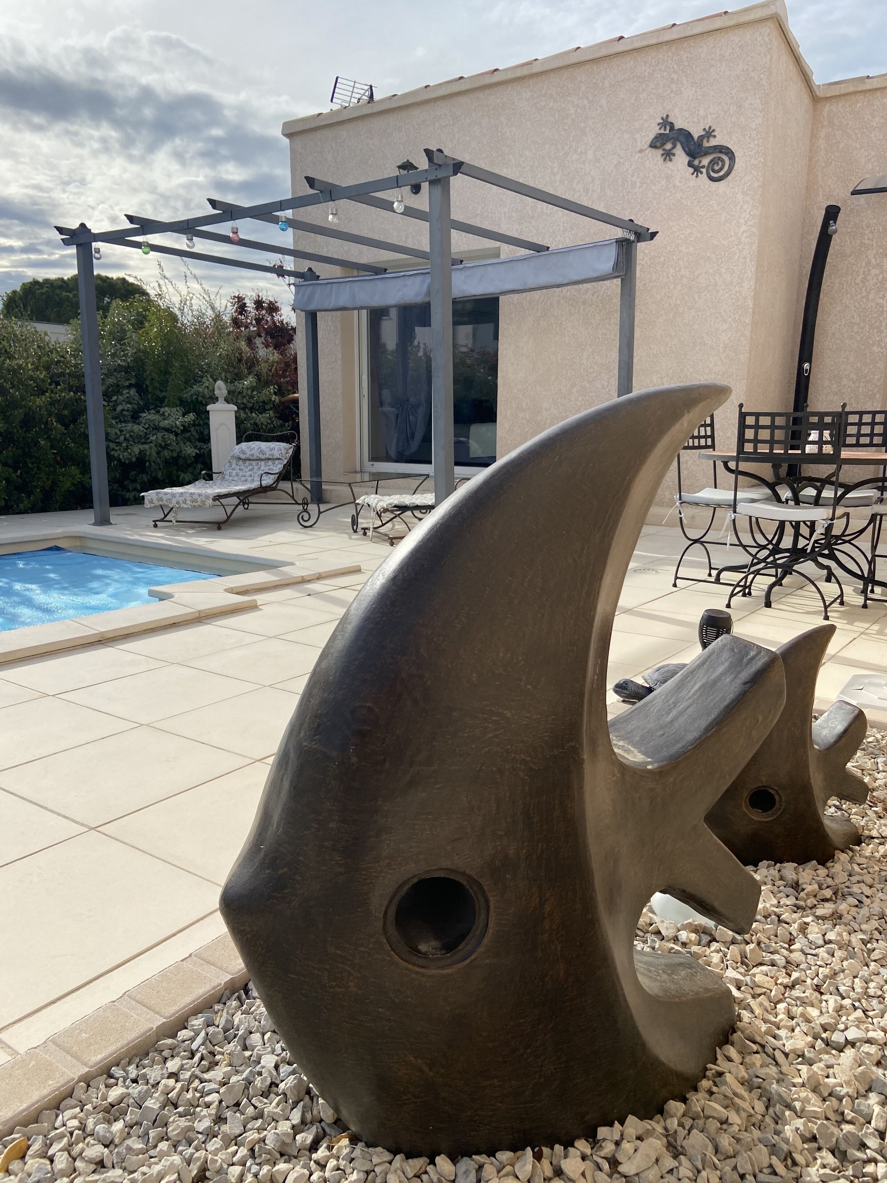 Une piscine avec des chaises longues et une pergola.