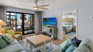 A hotel room with a balcony, a TV, a bed, and a dining area. - Beautiful Pointe Santo Overlooking Gulf (Sanibel)