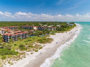 A resort with multiple buildings, a beach, and ocean views.