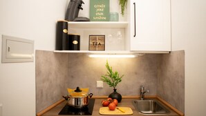 Cocina moderna con estufa integrada, un lavaplatos y una encimera. Hay tomates y una tabla de cortar en la encimera.