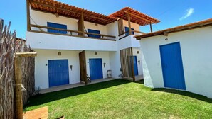 Un bâtiment à deux étages avec des portes bleues et une clôture en bois.