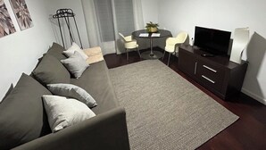 A modern living room with a sofa, a TV, a dining table, and a ceiling fan. - 2Stay - A1 Local Accommodation with swimming pool (Ponta Delgada)