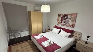 A neatly arranged bedroom with a bed, a wardrobe, a chair, a bedside table, and a hanging light fixture. - 2Stay - A1 Local Accommodation with swimming pool (Ponta Delgada)