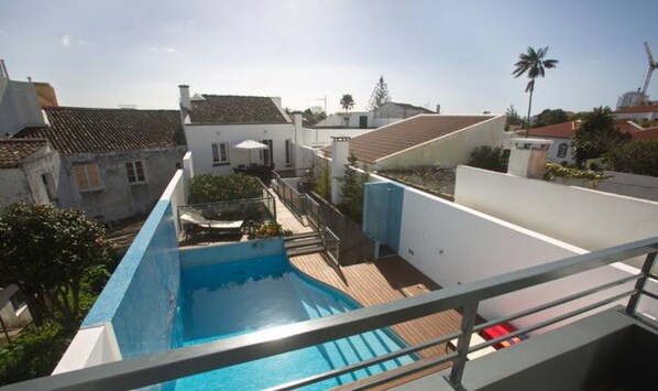 Ein Pool mit Blick auf die umliegende Nachbarschaft, einschließlich Häusern und einer Palme.