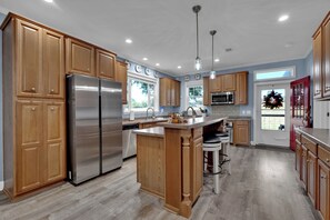 Une cuisine moderne avec des meubles en bois, des appareils en acier inoxydable et un îlot central.