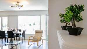 Ett modernt matområde med ett glasbord, stolar och utsikt över omgivningen.