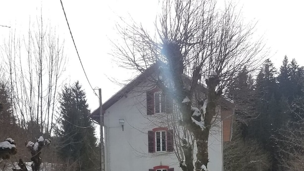 A snow-covered landscape with a white building featuring red window shutters and a sign indicating 'Cascade'. - LE GRAND TETRAS in a charming property in the heart of the Blue Spring area (Montperreux)