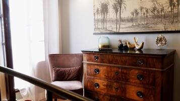 A room with a wooden dresser, a cushioned chair, and a map on the wall.