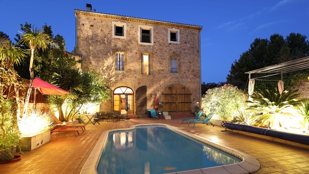 A stone building with a swimming pool, outdoor seating, and tropical plants. - Maison Dix (Neffies)