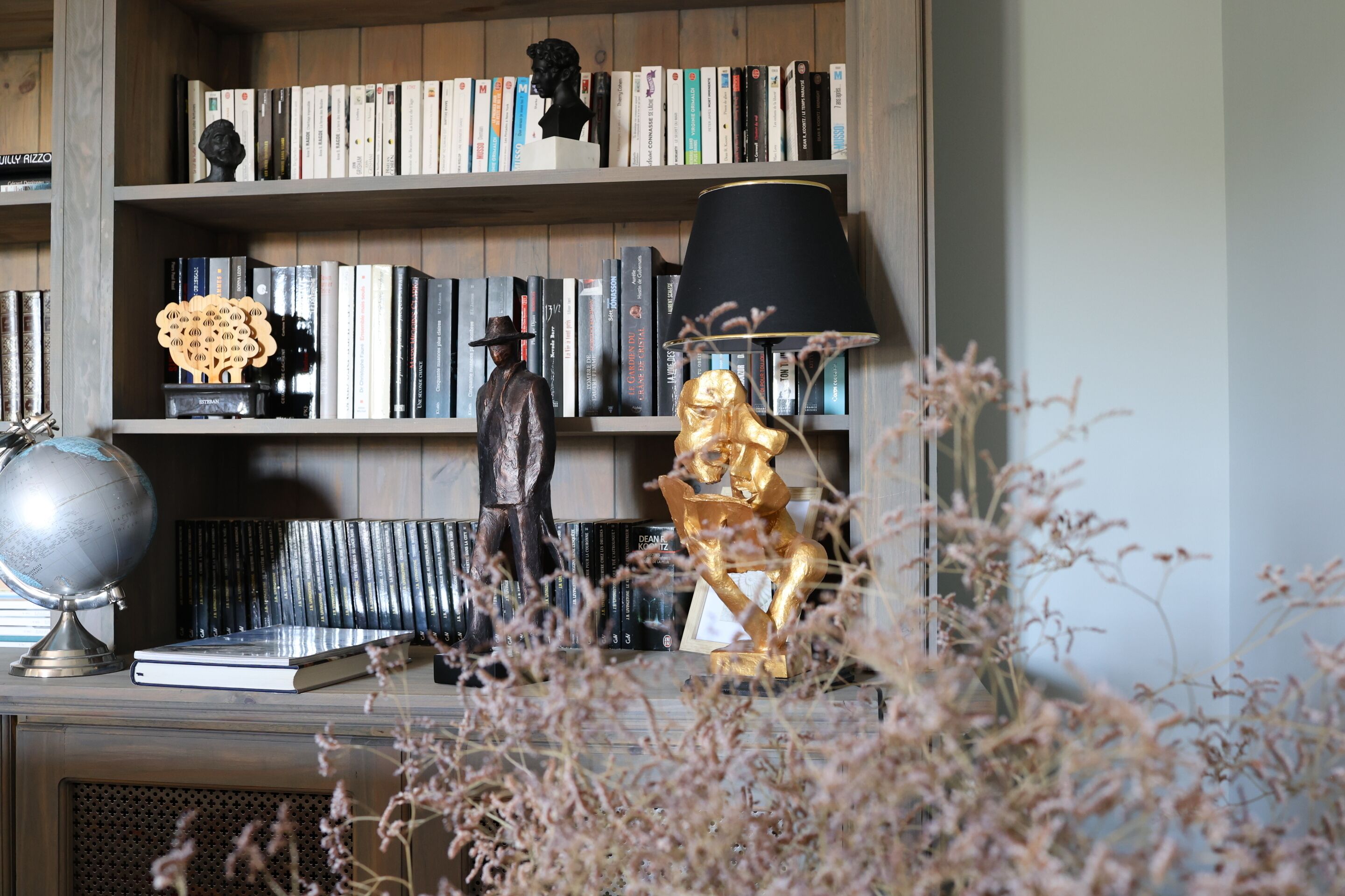 Ein Bücherregal mit Büchern, einem Globus und Dekorationselementen.