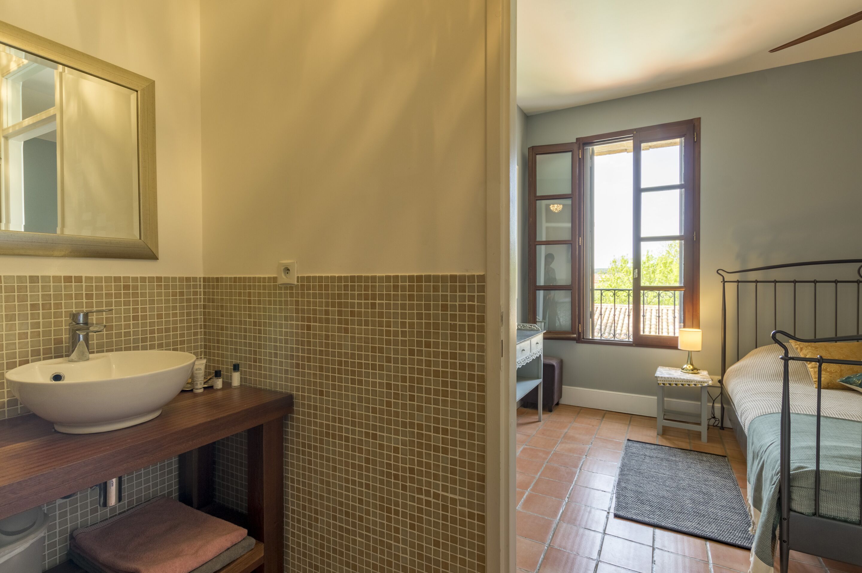 A bathroom with a large sink, mirror, and tiled walls.