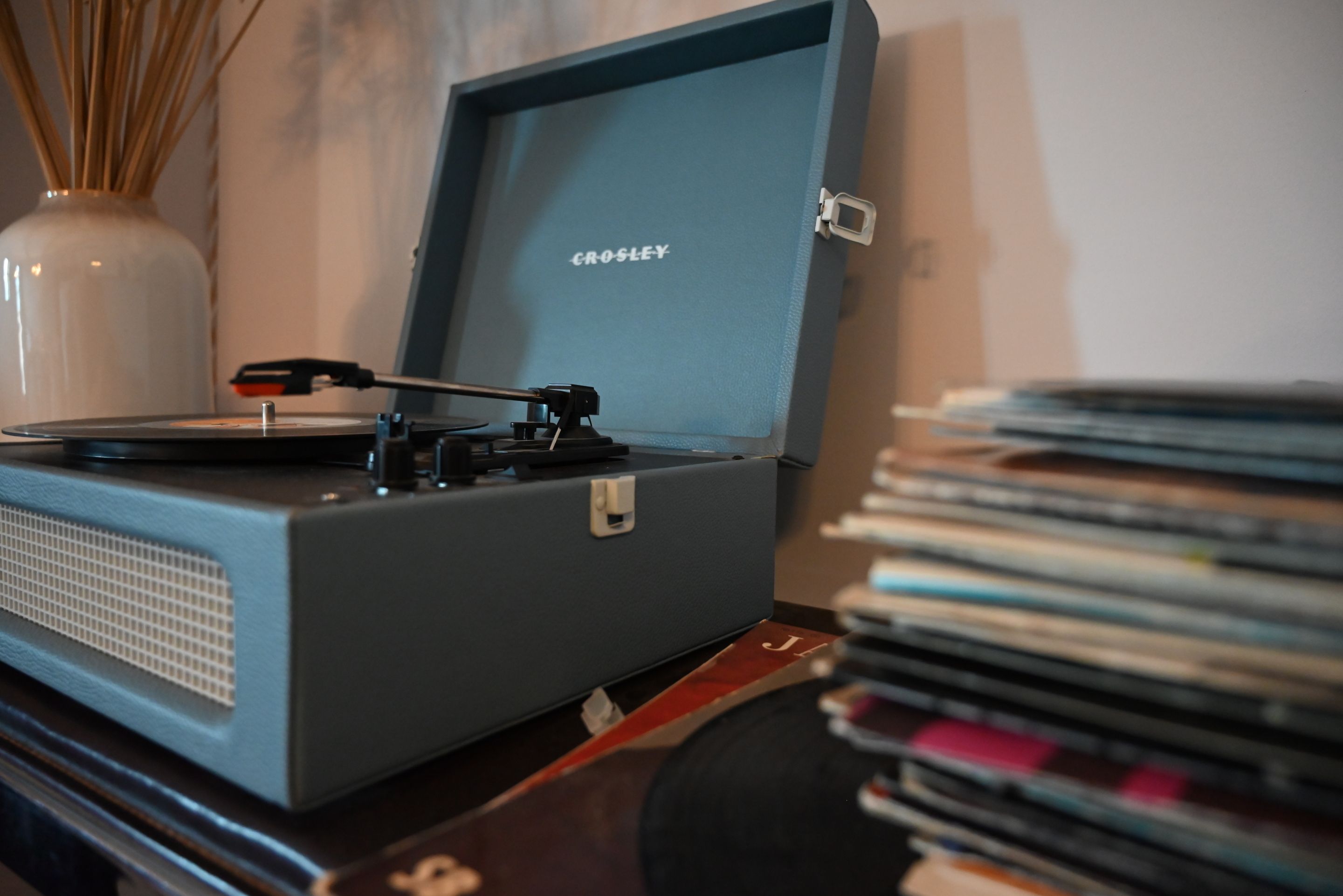 A turntable with a record on it, placed on a wooden surface.